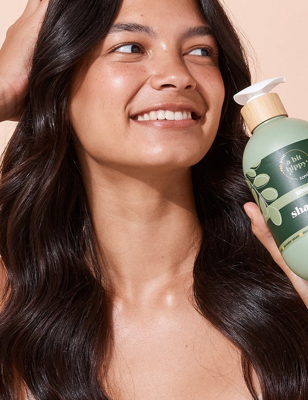A bit Hippy Sensitive Shampoo held by a smiling woman
