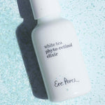 Ere Perez White Tea Phyto-Retinol Elixir bottle lying among scattered pale blue crystals