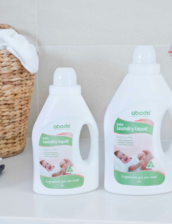 Abode Laundry Liquid Baby with folded towels in a laundry setting