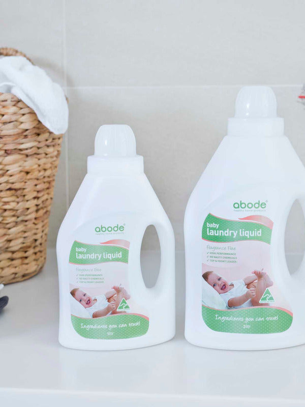Abode Laundry Liquid Baby with folded towels in a laundry setting