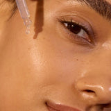 Close-up face applying ACURE Argan Oil with a dropper