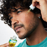 Man applying ACURE Radically Rejuvenating Bakuchiol Serum to his face
