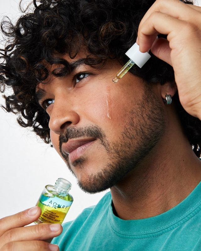 Man applying ACURE Radically Rejuvenating Bakuchiol Serum to his face