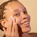 Woman applying ACURE Brightening Day Cream to her face