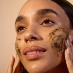 Model applying ACURE Brightening Facial Scrub to her face