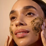 Model applying ACURE Brightening Facial Scrub to her face