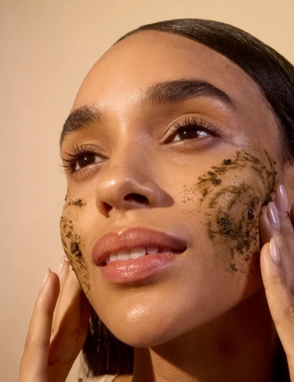 Model applying ACURE Brightening Facial Scrub to her face