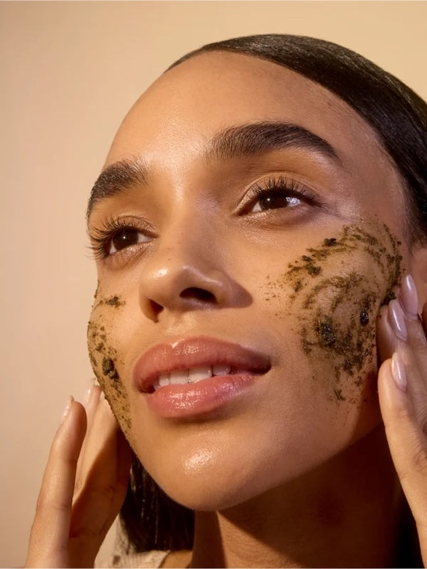 Model applying ACURE Brightening Facial Scrub to her face