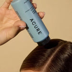 Model applying ACURE Dry Shampoo for All Hair Types