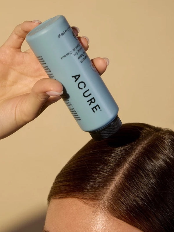 Model applying ACURE Dry Shampoo for All Hair Types