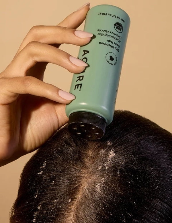 Brunette model applying ACURE Dry Shampoo directly to her roots