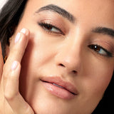 Close-up face applying ACURE Radically Rejuvenating Eye Cream