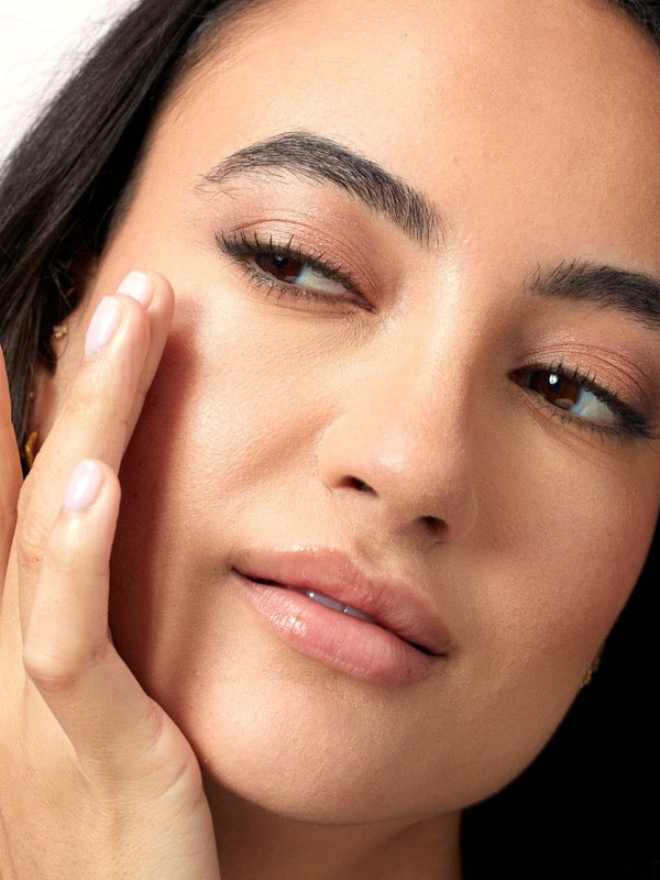 Close-up face applying ACURE Radically Rejuvenating Eye Cream