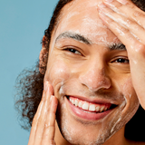 Man cleansing his face with ACURE Resurfacing Glycolic Cleanser