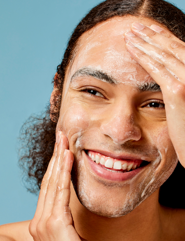 Man cleansing his face with ACURE Resurfacing Glycolic Cleanser