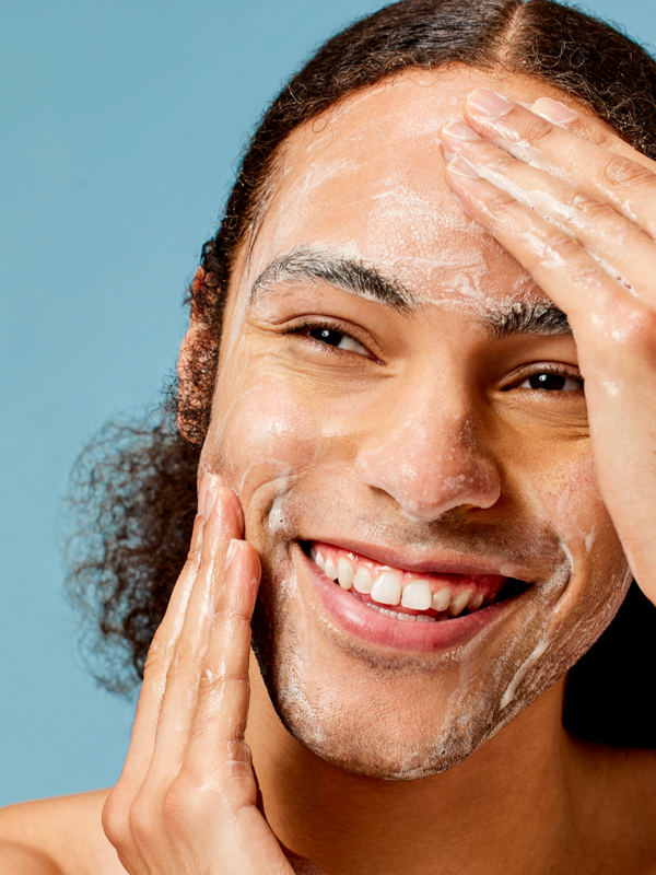 Man cleansing his face with ACURE Resurfacing Glycolic Cleanser