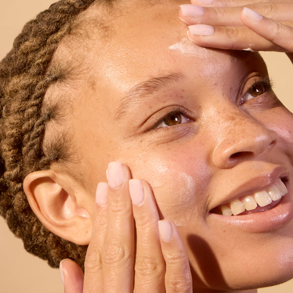 Woman applying Acure Revived Radiance Overnight Mask