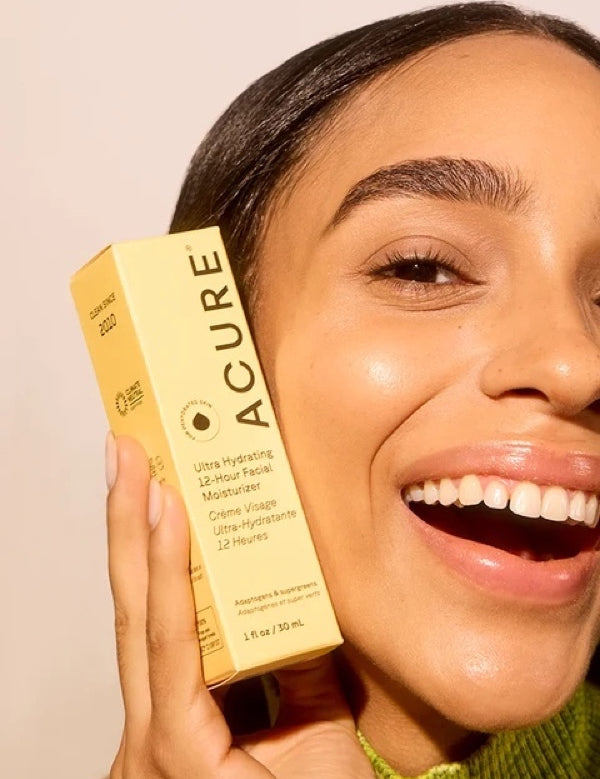 Model holding ACURE Ultra Hydrating 12 Hour Facial Moisturizer beside her face