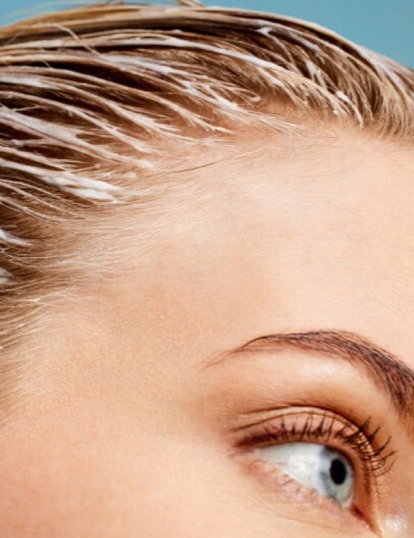 Close-up of ACURE Vivacious Volume Shampoo worked through wet hair