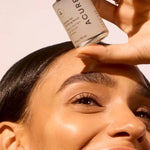 Model holding ACURE Zombie Cell Clarifying Serum beside her face