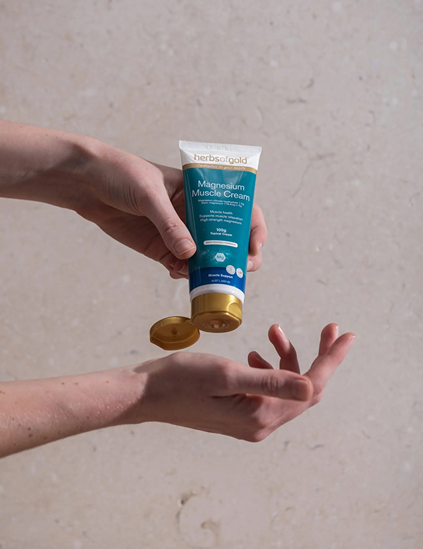 Herbs of Gold Magnesium Muscle Cream being applied to the hand