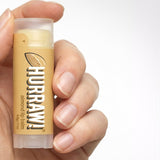 Hand holding Hurraw! Organic Lip Balm - Almond 4.8g