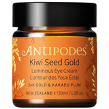 Antipodes Kiwi Seed Gold Luminous Eye Cream in an amber glass jar with an orange and gold botanical label and a wide black lid, on white.