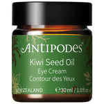 Antipodes Kiwi Seed Oil Eye Cream in an amber glass jar with a green label, gold botanical details and a wide black lid, on white.