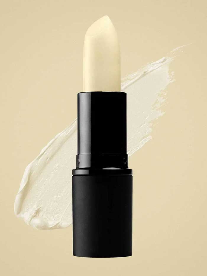 A tube of Antipodes Kiwi Seed Oil Lip Conditioner 4g in a black casing is shown against a beige background, with a smear of the nourishing lip balm behind it.
