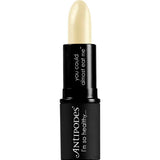 A 4g tube of Antipodes Kiwi Seed Oil Lip Conditioner features a creamy, pale yellow balm in a sleek black case with "you could almost eat me" and "ANTIPODES I’m so healthy…" printed on the packaging.
