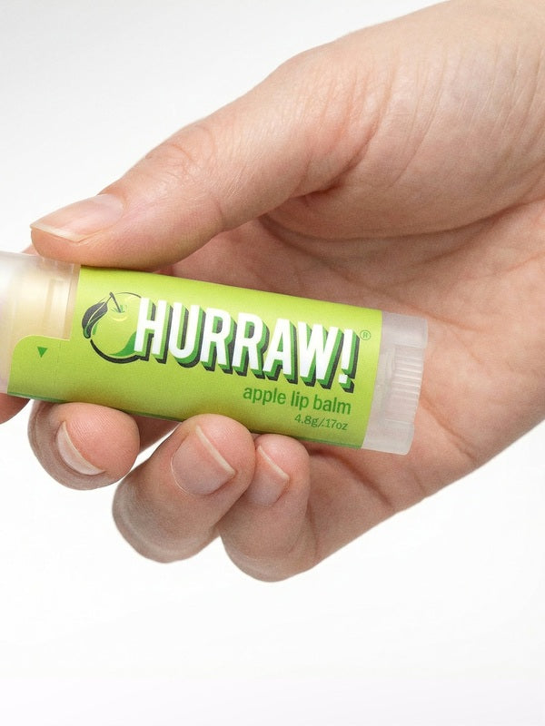 Hand holding Hurraw! Organic Lip Balm - Apple 4.8g