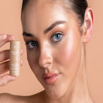 Model holding Avocado Zinc SPF50 Natural Bronzer in Light-Medium beside her highlighted cheek.