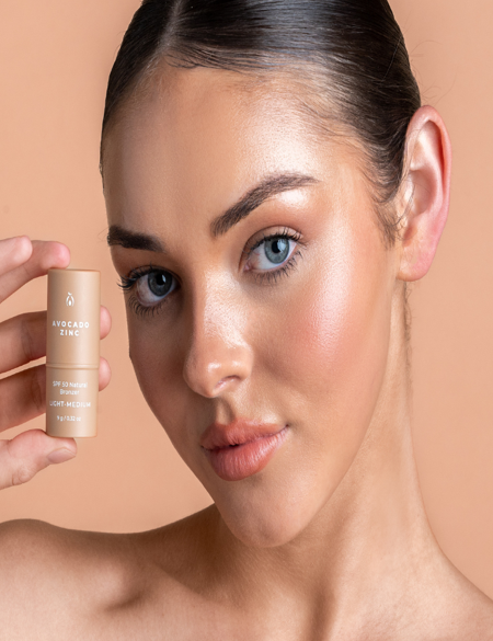 Model wearing Avocado Zinc SPF 50 Natural Bronzer in Light-Medium