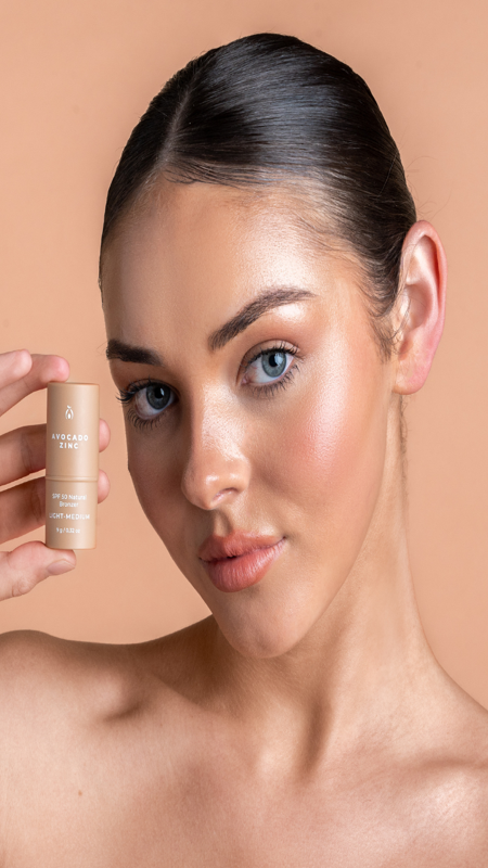 Model wearing Avocado Zinc SPF 50 Natural Bronzer in Light-Medium