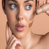 Model applying Avocado Zinc SPF50 Natural Bronzer in Medium-Dark directly to her cheek.