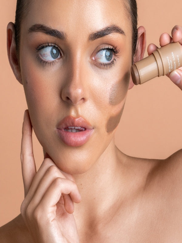 Model applying Avocado Zinc SPF50 Natural Bronzer in Medium-Dark directly to her cheek.