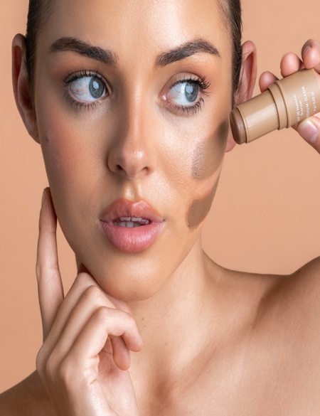 Model applying Avocado Zinc SPF 50 Natural Bronzer in Medium-Dark