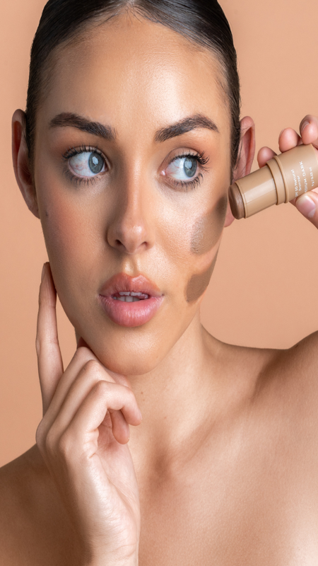 Model applying Avocado Zinc SPF 50 Natural Bronzer in Medium-Dark