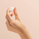 Hand holding a Herbs of Gold Magnesium Chewable raspberry tablet