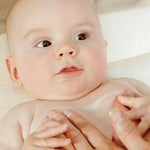 Applying Weleda White Mallow Body Lotion to baby's skin