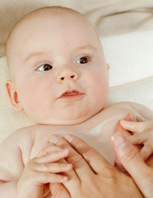 Applying Weleda White Mallow Body Lotion to baby's skin