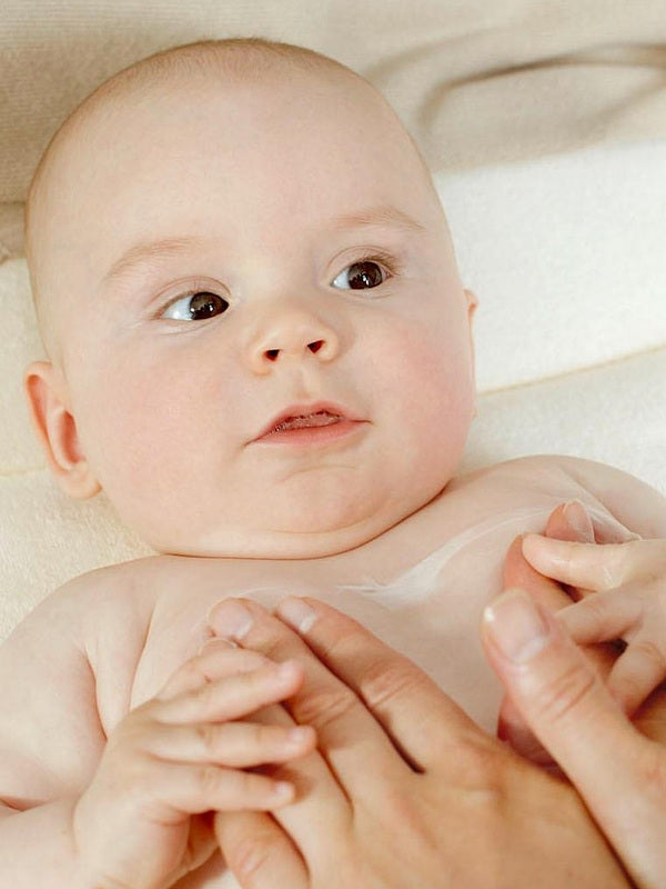 Applying Weleda White Mallow Body Lotion to baby's skin