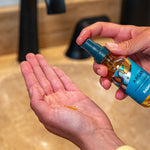 Badger Argan Hair Oil dispensed into a hand