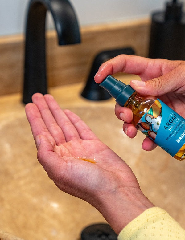 Badger Argan Hair Oil dispensed into a hand