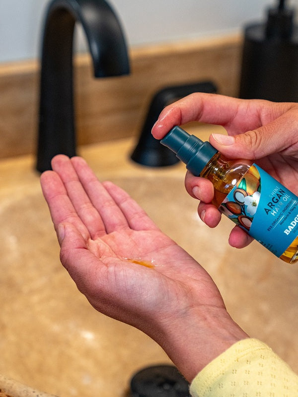 Badger Argan Hair Oil dispensed into a hand