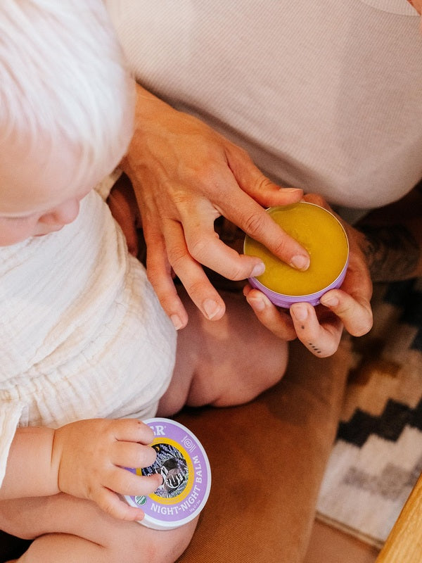 Parent using Badger Night-Night Balm with a child