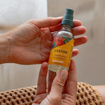 Badger Castor Hair Oil held in both hands
