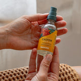 Badger Castor Hair Oil held in both hands