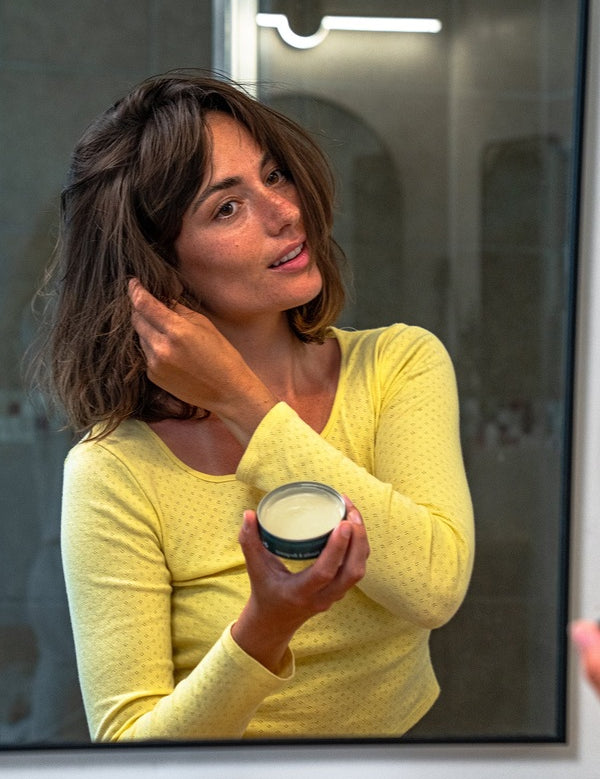 Woman styling her hair with Badger Hair Pomade
