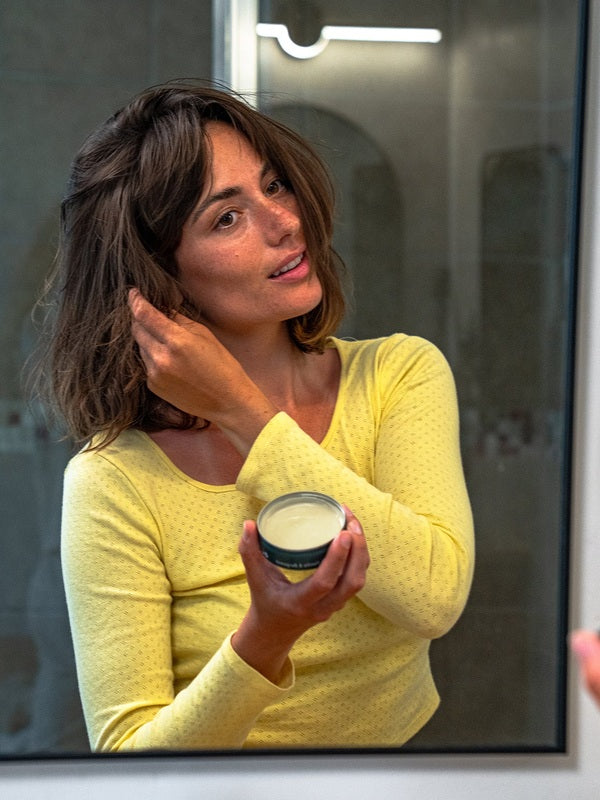 Woman styling her hair with Badger Hair Pomade